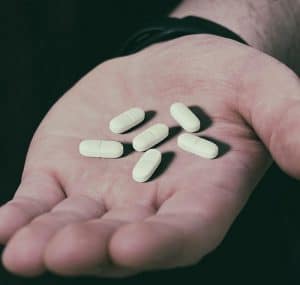 man holding pills in his hand